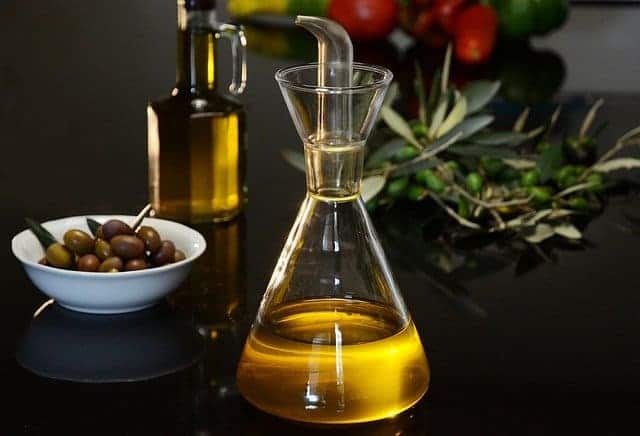 Flakon aus Öl und grünen Oliven