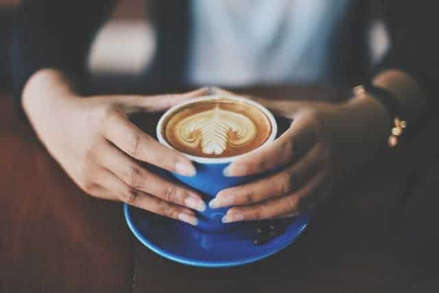 Tasse Kaffee in den Händen halten